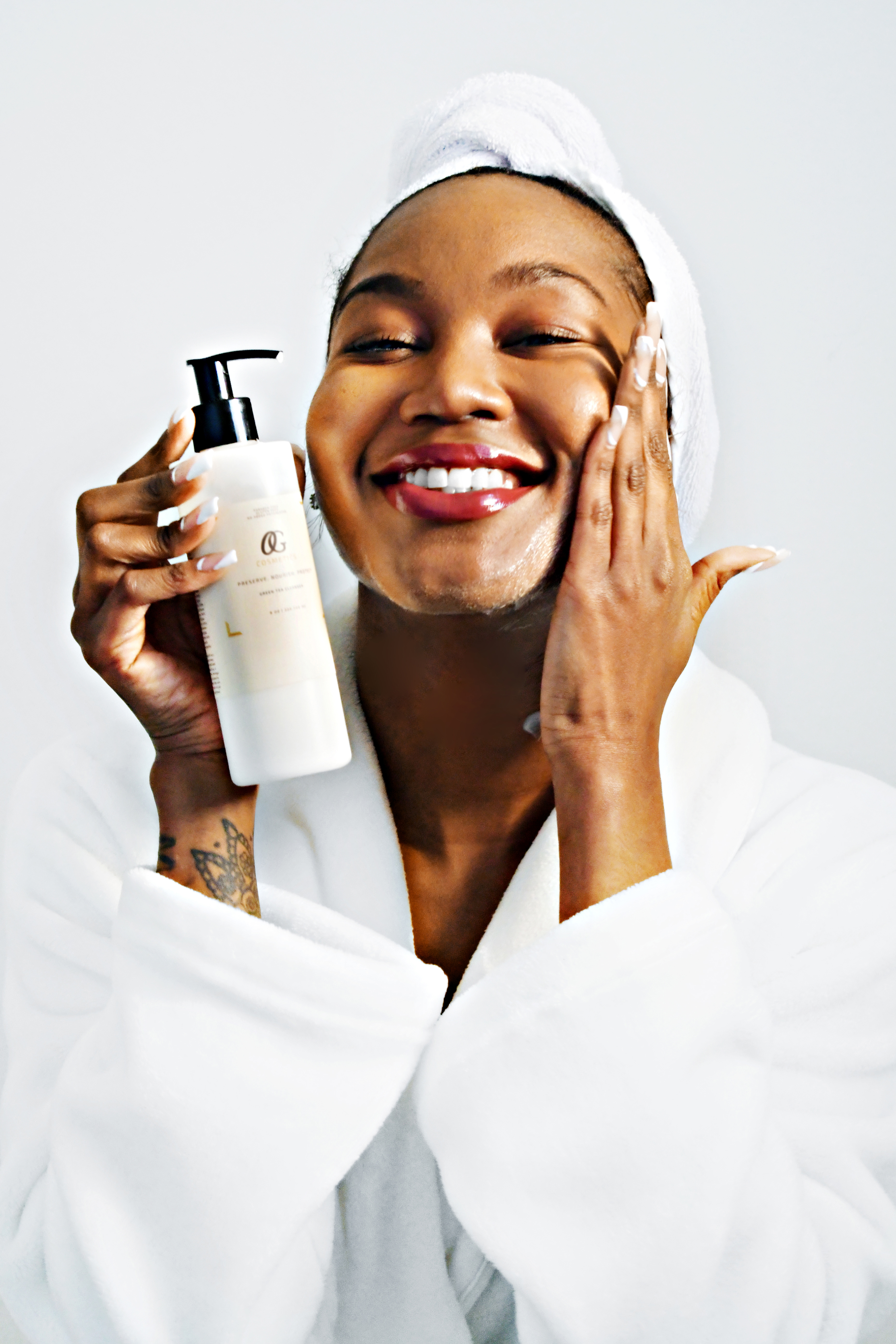 Nahjee, founder of OG Cosmetics, holding Green Tea Cleanser